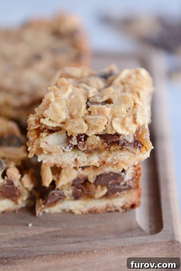 A stack of golden brown Caramel Oat Chocolate Chunk Shortbread Bars, showcasing their rich layers and gooey texture.