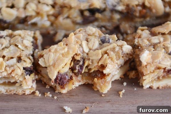 A close-up of a Caramel Oat Chocolate Chunk Shortbread Bar with a bite taken out, revealing the soft, chewy interior filled with melted chocolate and oats.