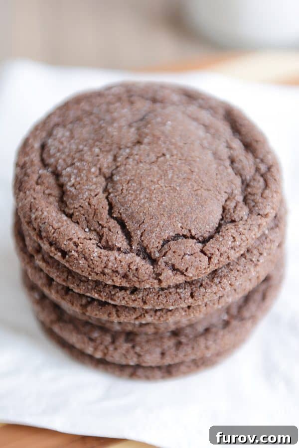 Top-down view of a stack of soft chocolate sugar cookies, perfectly round and coated in sugar.