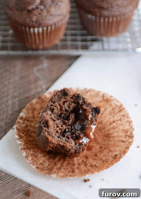 Half of a chocolate salted caramel muffin with caramel oozing out.