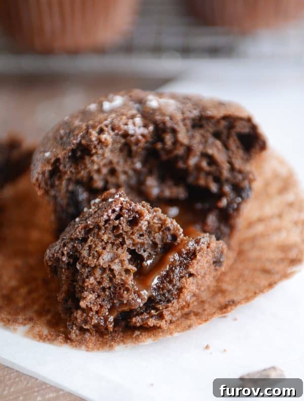 Half of a double chocolate salted caramel muffin with caramel oozing out.