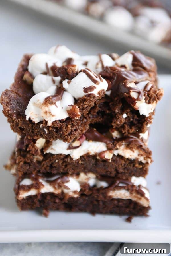 Three Mississippi Mud Bars stacked on top of each other on a white tray with a bite taken out of the top bar.