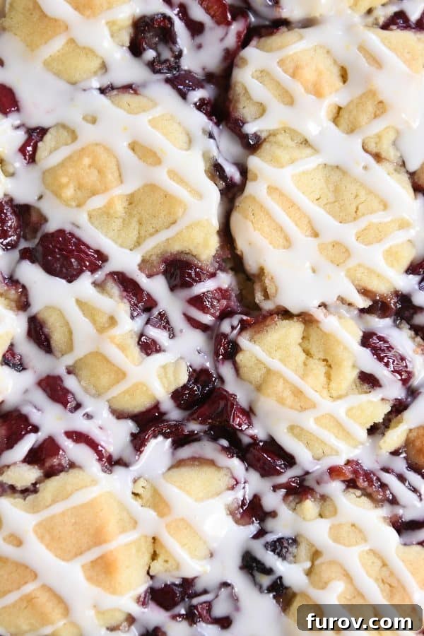 Close up view of the top of the cherry pie cookie bars, revealing the vibrant cherry filling peeking through the golden cookie crust.