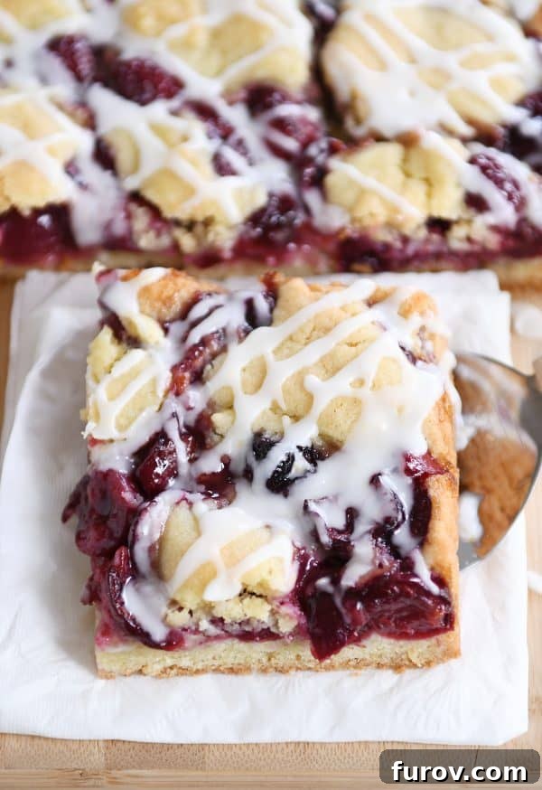 A single cherry pie cookie bar elegantly placed on a white napkin, highlighting its rustic charm.
