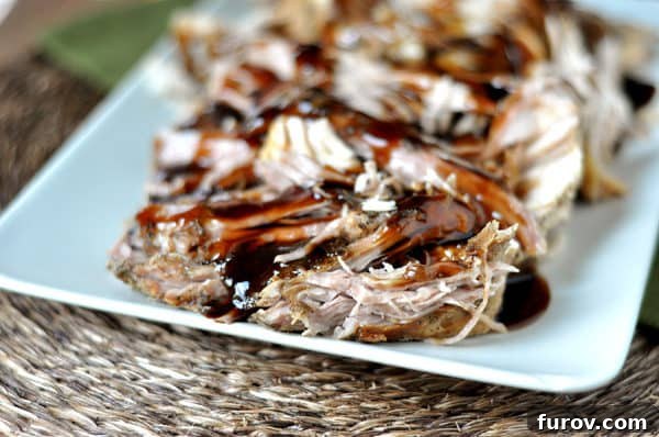 Sweet Balsamic Glazed Pork Loin, sliced and garnished with fresh herbs.