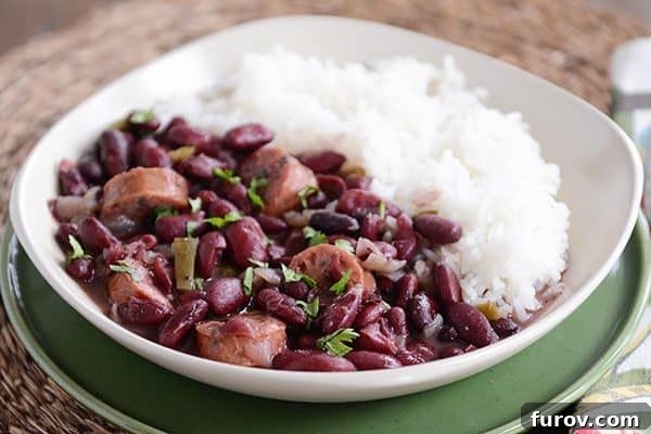Slow cooker Red Beans and Rice with chicken sausage, garnished with fresh herbs.