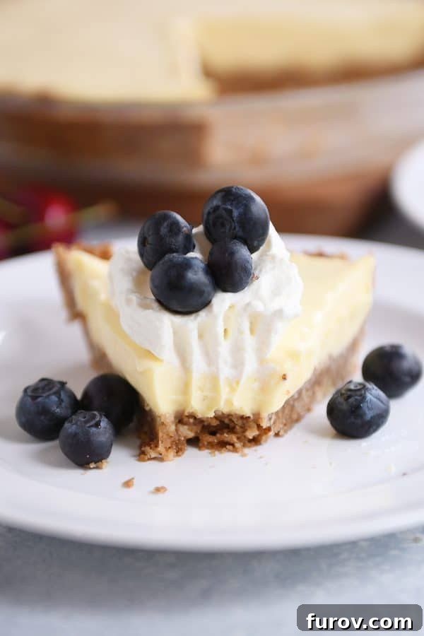 Berry Bliss Cream Pie with Toasted Pecan Graham Crust 2 A slice of berries and cream pie on a white plate with a bite taken out.