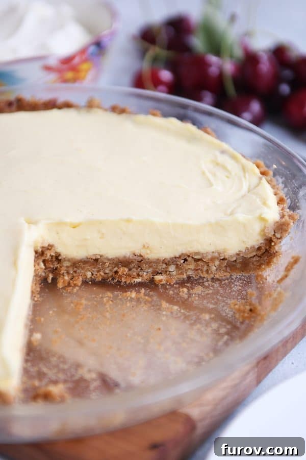 Berry Bliss Cream Pie with Toasted Pecan Graham Crust 3 Berries and cream pie in pie plate with a piece taken out.