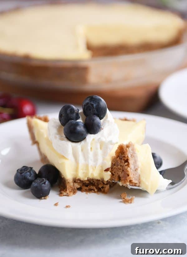 Berry Bliss Cream Pie with Toasted Pecan Graham Crust 5 Berries and cream pie on a white plate with a bite taken out.