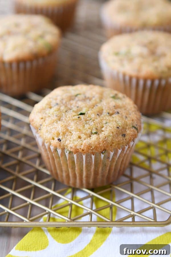 Freshly baked lemon poppy seed zucchini muffins cooling on a wire rack, ready to be enjoyed.