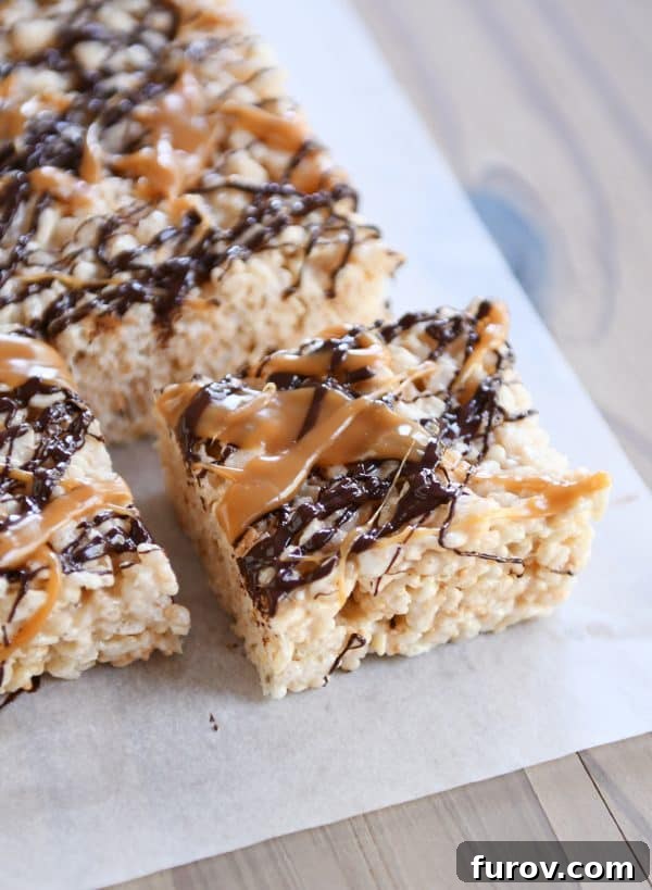 Toasted Coconut Caramel Crunch Bars 2 Toasted Coconut Caramel Rice Krispie Treats on parchment paper.