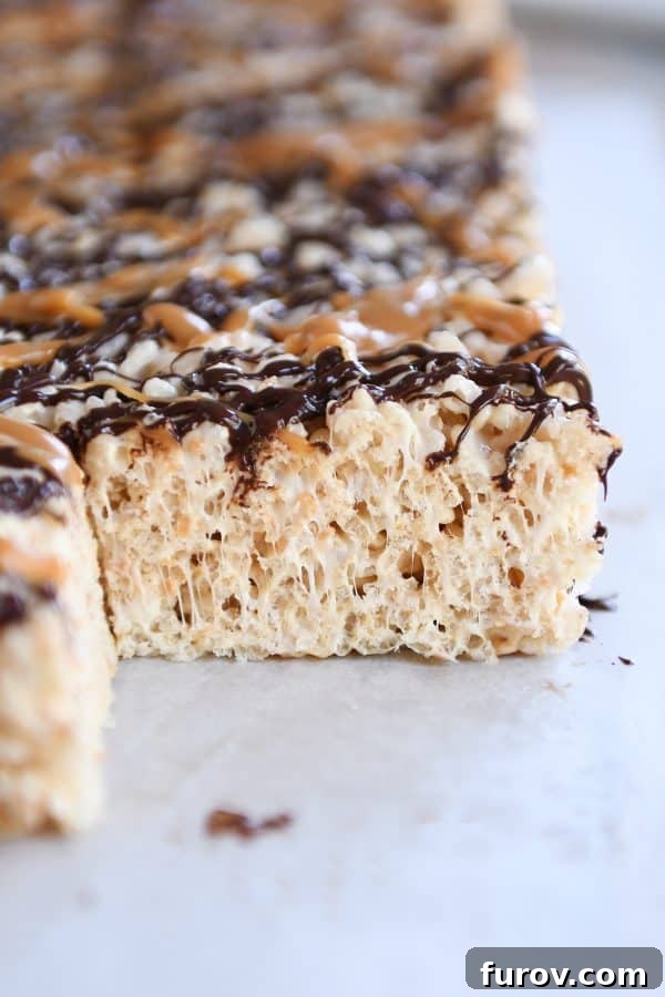 Toasted Coconut Caramel Crunch Bars 6 Toasted Coconut Caramel Rice Krispie Treats on parchment paper.