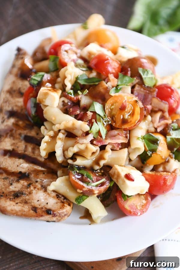 Ultimate Bruschetta Chicken Bacon Pasta 4 Close up of bruschetta chicken and bacon pasta on white plate.