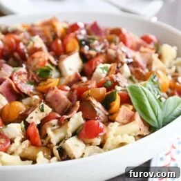Ultimate Bruschetta Chicken Bacon Pasta 5 Bruschetta chicken and bacon pasta in large white serving bowl with fresh basil.