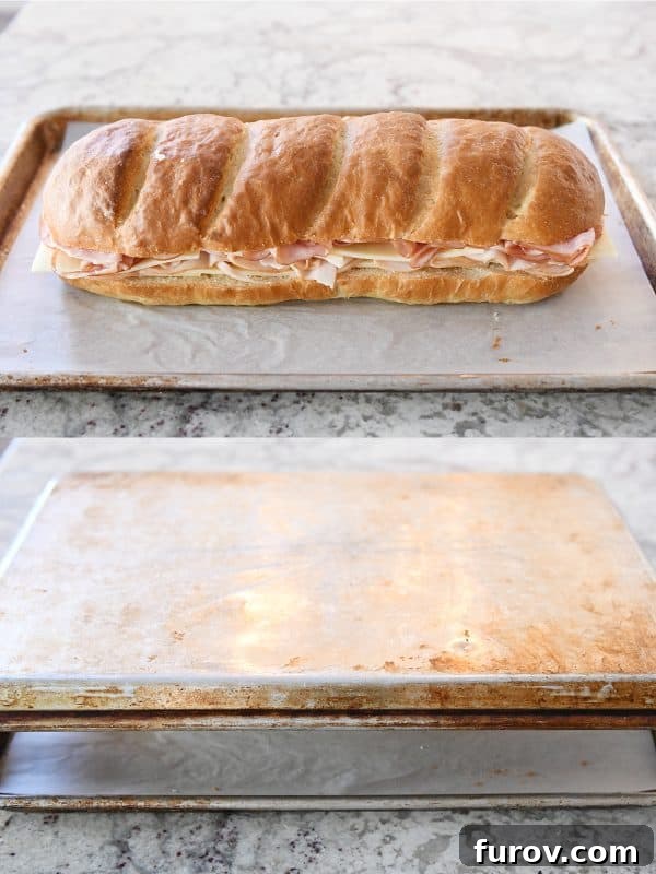 Assembling the sheet pan panini by placing the top bread layer and then another baking sheet on top for pressing.