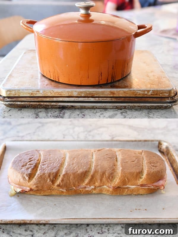 A heavy cast iron pot placed on top of a baking sheet to press down the sheet pan panini before it goes into the oven.