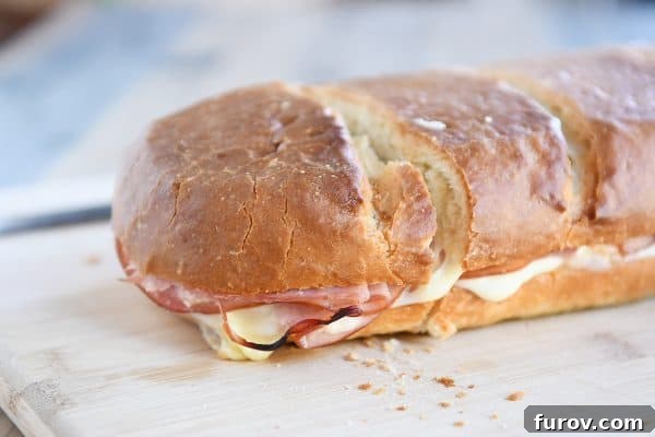 A close-up view of the cross-section of a ham and cheese sheet pan panini, showcasing the melted cheese and layers of ingredients.