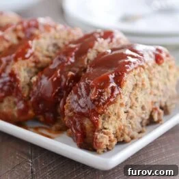 Slices of the best glazed meatloaf on white platter.