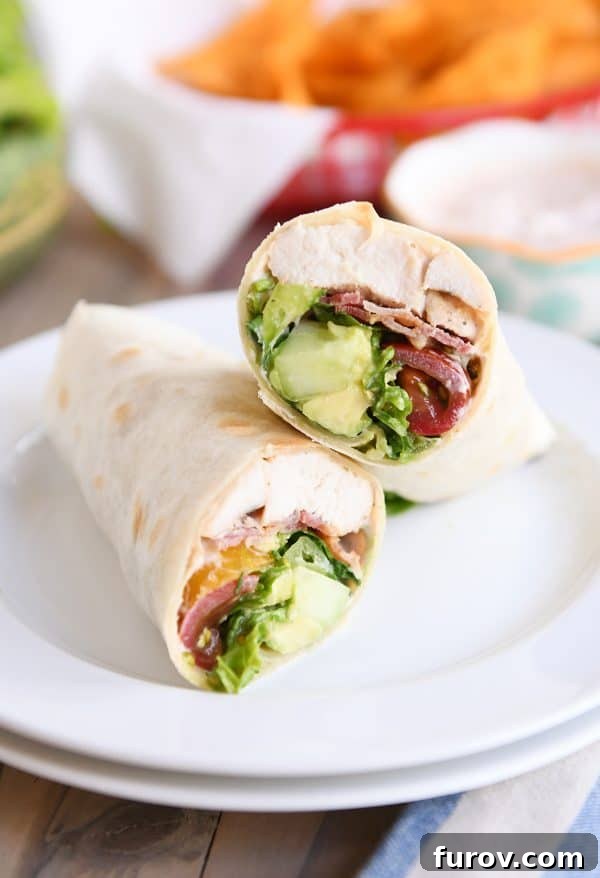 Craveable Chicken BLT Burritos with Creamy Southwest Dip 2 Half of a perfectly cut Chicken BLT Burrito with a creamy dipping sauce on a white plate, showcasing layers of grilled chicken, crispy bacon, fresh lettuce, and ripe tomato.