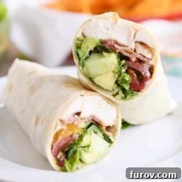 Chicken BLT burritos cut in half on white plate, ready to be served.