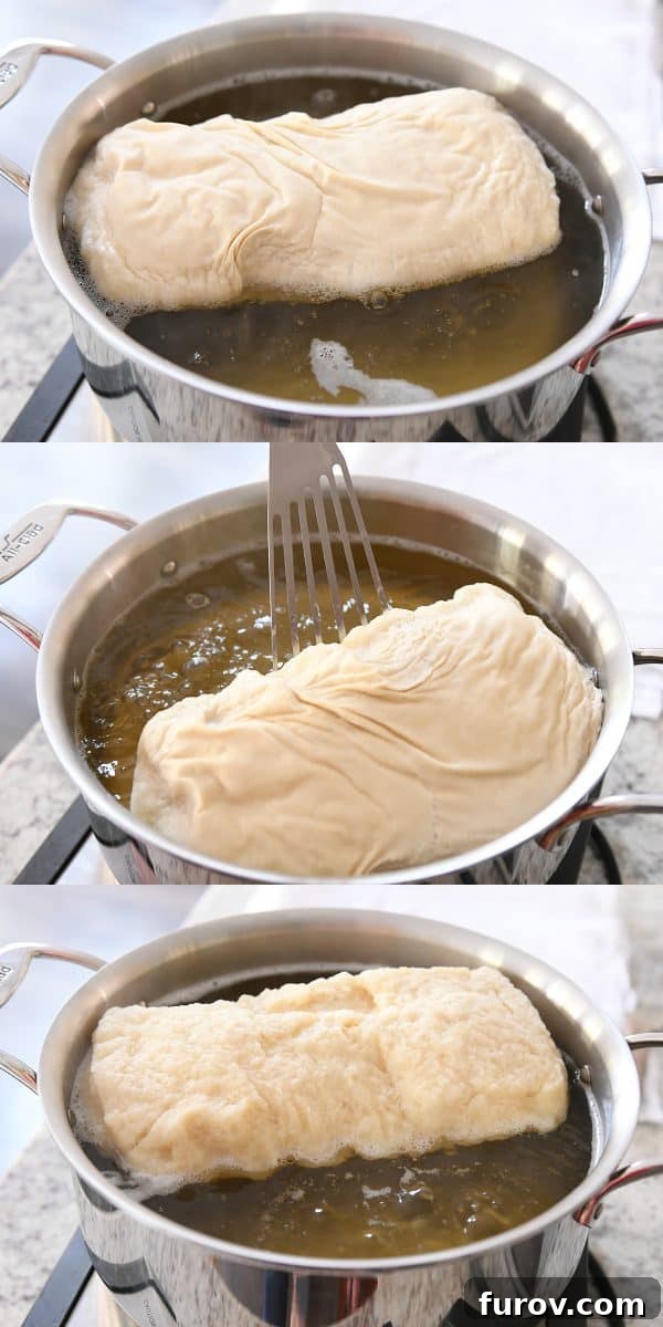 A loaf of bagel bread gently boiling in a pot of water, visibly transforming its surface as it cooks.