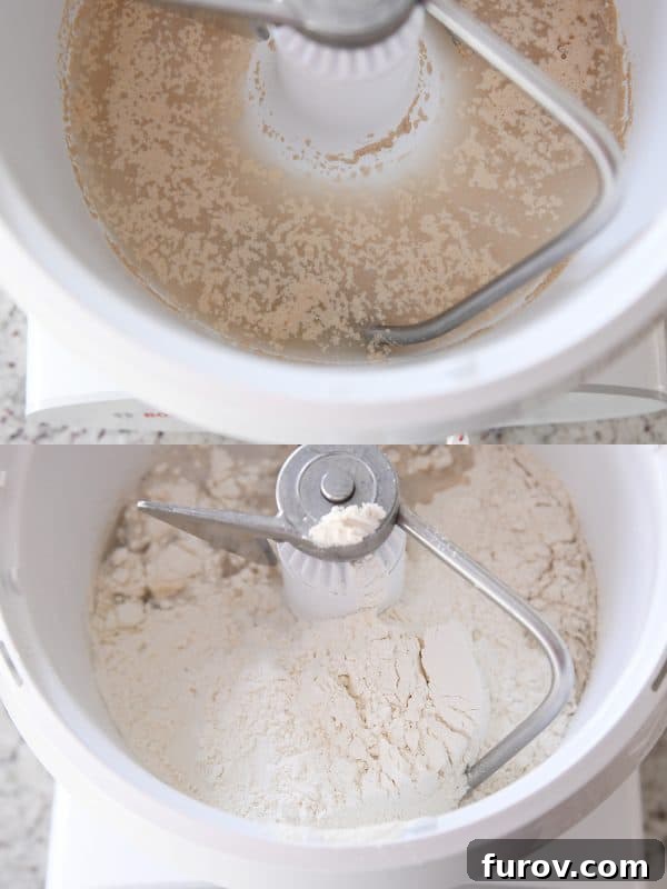 Yeast, warm water, honey, and a portion of flour being mixed together in a large Bosch mixing bowl, forming the initial shaggy dough for bagel bread.