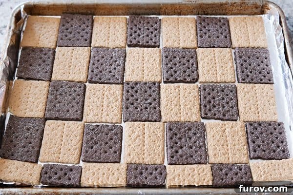 Effortless Peanut Butter Chocolate Graham Cracker Toffee 4 Tray of graham crackers arranged in a single layer, ready for the easy graham cracker toffee preparation.