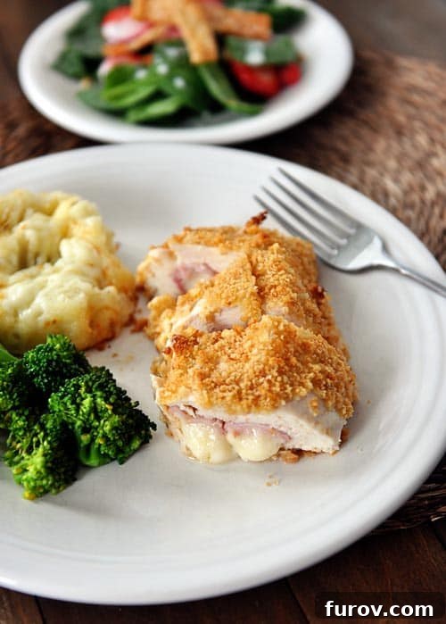 Plated Chicken Cordon Bleu served with roasted broccoli and potatoes, ready for a gourmet meal.