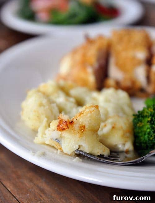 Creamy Chantilly potatoes and a perfectly cooked chicken breast on a pristine white plate, showcasing a gourmet meal.