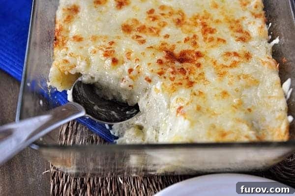 A casserole dish brimming with creamy, golden, cheesy Chantilly potatoes, with a scoop removed, inviting you to indulge.