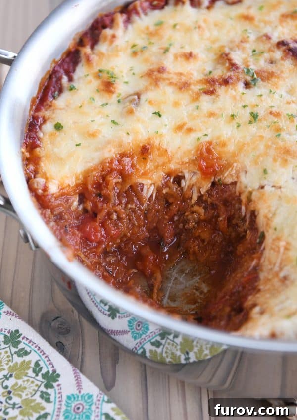 Spaghetti squash spaghetti bake topped with cheese in pan.