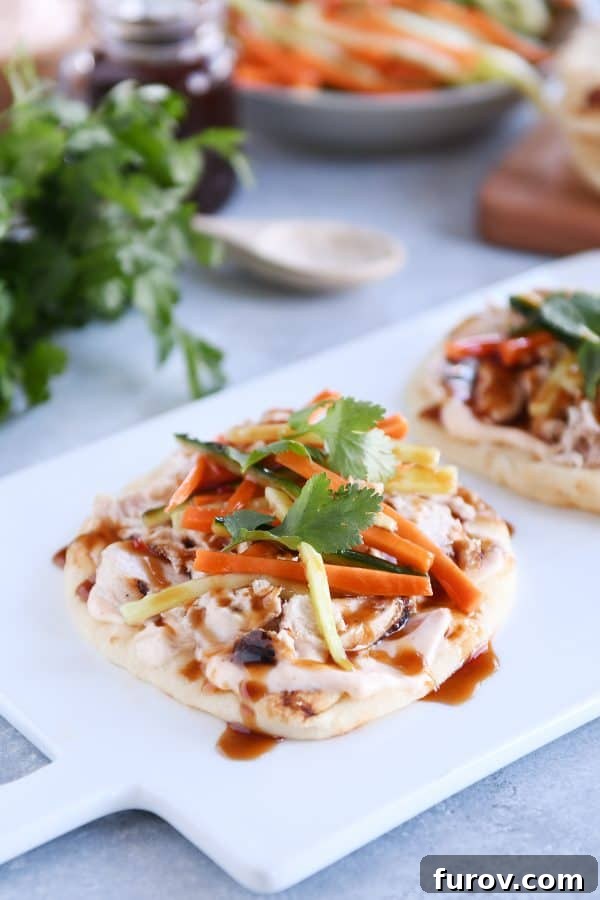 Fast Chicken Banh Mi Flatbread with Two Amazing Sauces 2 Chicken banh mi flatbread with pickled cucumbers and carrots on white platter, showcasing vibrant colors and fresh ingredients.