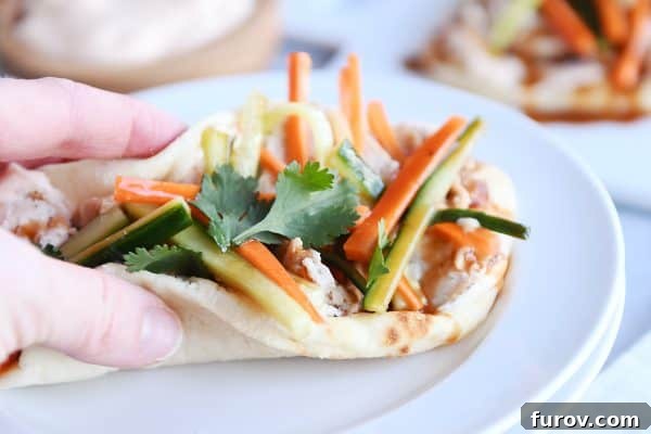Fast Chicken Banh Mi Flatbread with Two Amazing Sauces 4 Folded chicken banh mi flatbread like a taco ready to eat on white plate, highlighting its versatility.