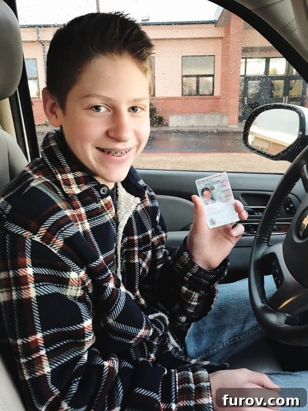 A teenager behind the wheel of a car, with a parent in the passenger seat, showing the process of learning to drive