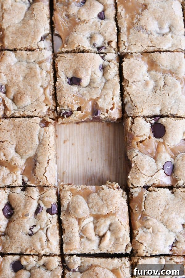 Salted Caramel Brown Butter Chocolate Chip Bars 4 Slab of salted caramel brown butter chocolate chip bars cut into squares on wood cutting board.