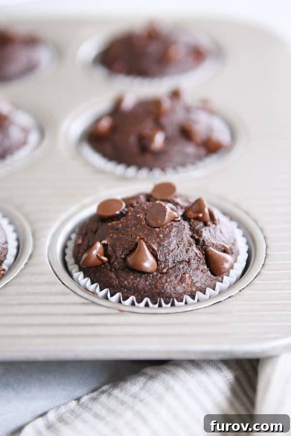 Decadent Gluten-Free Double Chocolate Banana Blender Muffins 7 A single baked Double Chocolate Banana Blender Muffin nestled in a metal muffin tin, ready to be enjoyed.