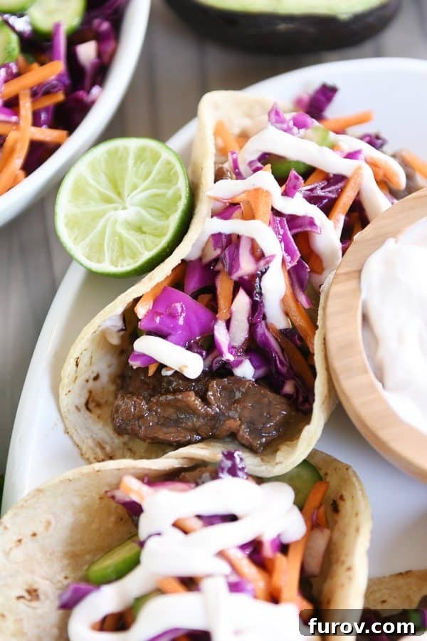 Game Changing Korean Beef Tacos with Zesty Slaw and a Sauce Beyond Compare 6 A beautifully presented platter of Korean beef tacos, topped with fresh slaw and drizzled with creamy sauce, ready to be enjoyed.