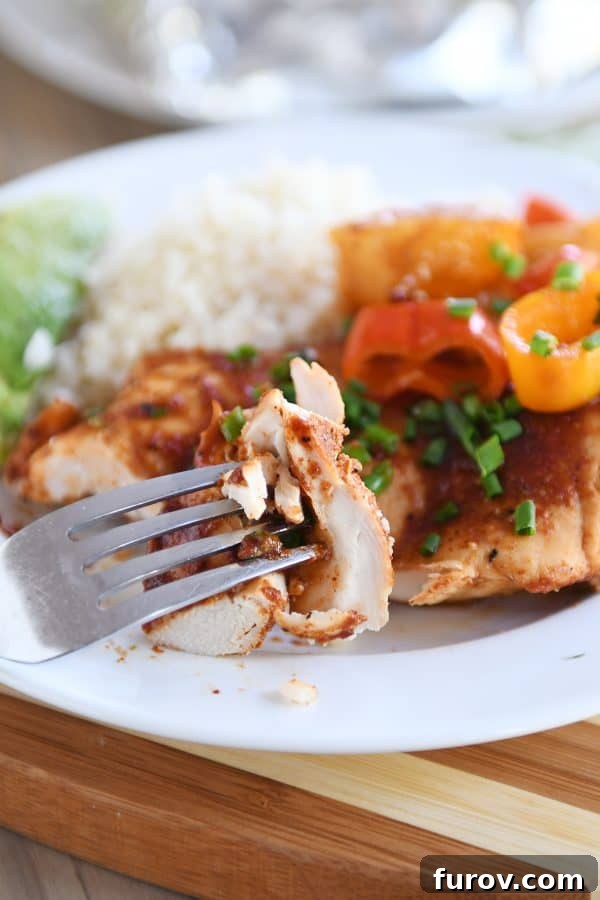 Hawaiian Pineapple Chicken Foil Packs Grilled or Baked 3 Fork taking a bite of BBQ Hawaiian chicken off a plate of chicken, peppers, and rice, highlighting the deliciousness of the meal.