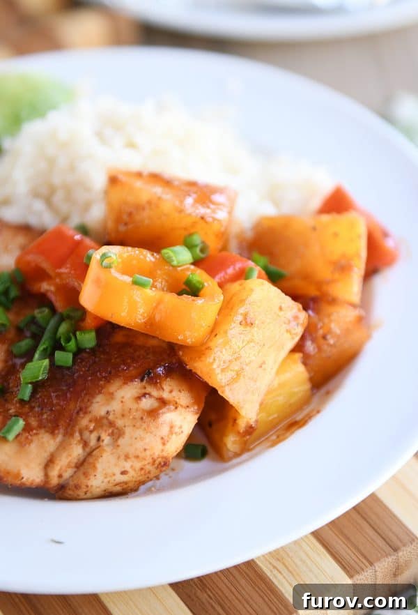 Hawaiian Pineapple Chicken Foil Packs Grilled or Baked 6 White plate showcasing a BBQ Hawaiian Chicken foil packet meal served alongside cauliflower rice, garnished with fresh herbs.