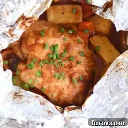 BBQ Hawaiian chicken foil packet opened with chicken, peppers and pineapple inside, ready to be served.