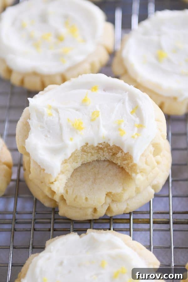 Easy Swig Lemon Sugar Cookies with Bright Lemon Frosting 7 Bite taken out of frosted lemon swig sugar cookies.