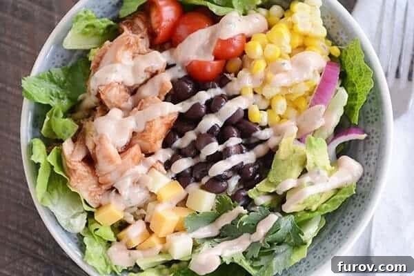 Effortless Entertaining Build Your Own Meals For Any Crowd Recipes and Tips 11 A vibrant BBQ chicken salad cilantro lime rice bowl, topped with fresh vegetables and creamy dressing.