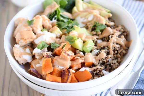 Effortless Entertaining Build Your Own Meals For Any Crowd Recipes and Tips 12 An assembled Buddha bowl with colorful vegetables, grains, and a creamy peanut sauce in a white bowl.