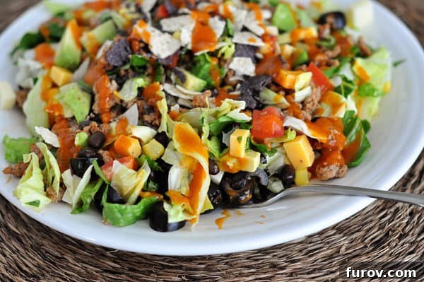 Effortless Entertaining Build Your Own Meals For Any Crowd Recipes and Tips 5 A colorful and hearty chopped taco salad, featuring fresh ingredients and a creamy dressing.