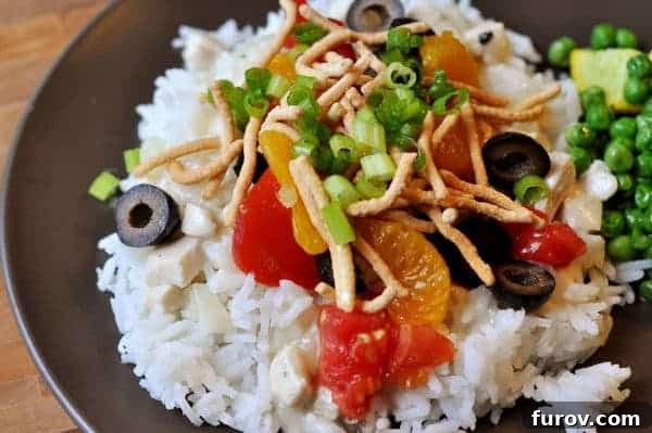 Effortless Entertaining Build Your Own Meals For Any Crowd Recipes and Tips 6 A serving of Hawaiian Haystacks, featuring a creamy chicken sauce over rice, topped with a variety of colorful ingredients.