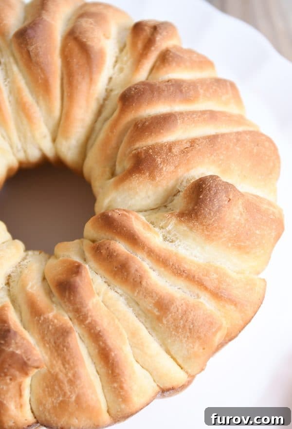 A stunning shot of the finished pull apart bundt bread on a white platter, inviting hands to break off a warm, buttery piece.