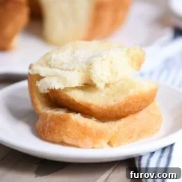 Stack of buttery pull apart bundt bread pieces on white plate.