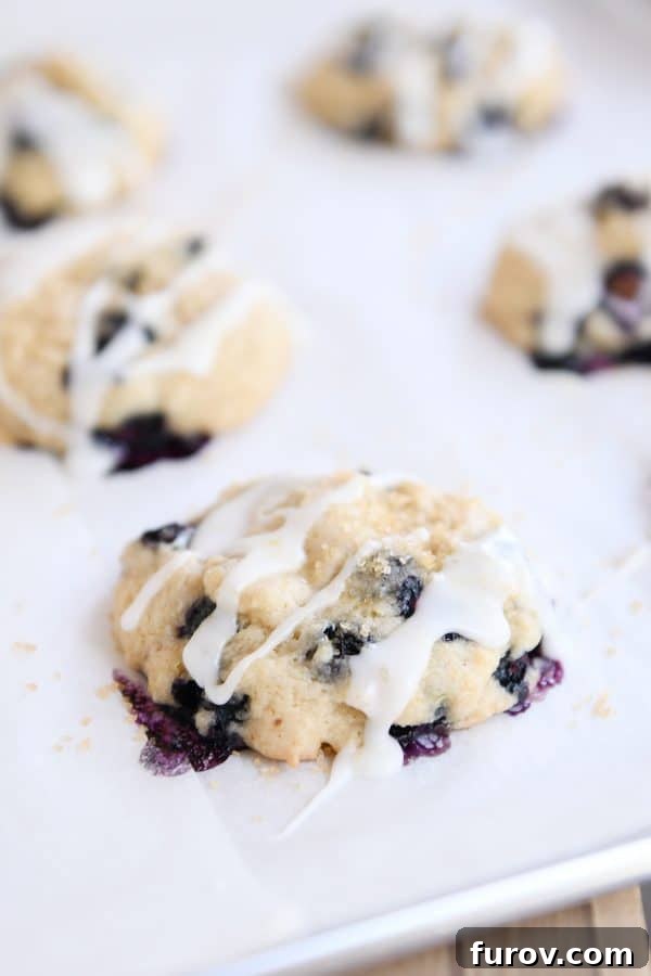 Blueberry Muffin-Top Cookies 2 Glazed blueberry muffin cookie on parchment lined baking sheet.