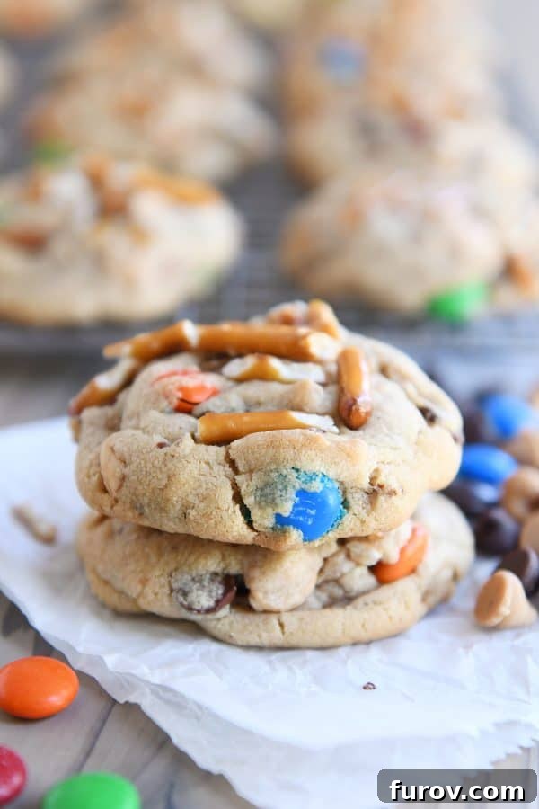 Sweet and Salty Peanut Butter Kitchen Sink Cookies 9 A stack of two perfectly baked peanut butter kitchen sink cookies, inviting you to indulge in their sweet and salty goodness.