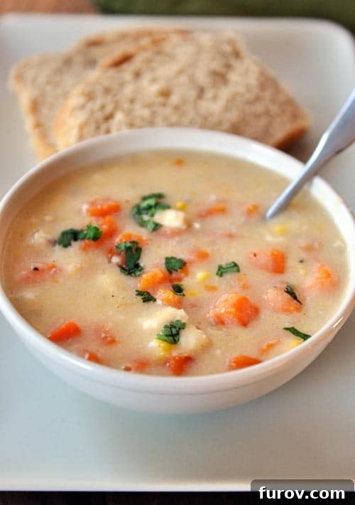 Hearty Chicken, Sweet Potato, and Corn Chowder 2 A vibrant bowl of hearty Chicken Corn Chowder with Sweet Potatoes, featuring tender chicken, golden corn, and sweet potato chunks, garnished with fresh herbs.